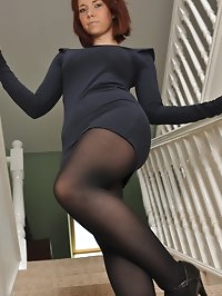 Ellie Rose in a black dress, pantyhose and high heels..